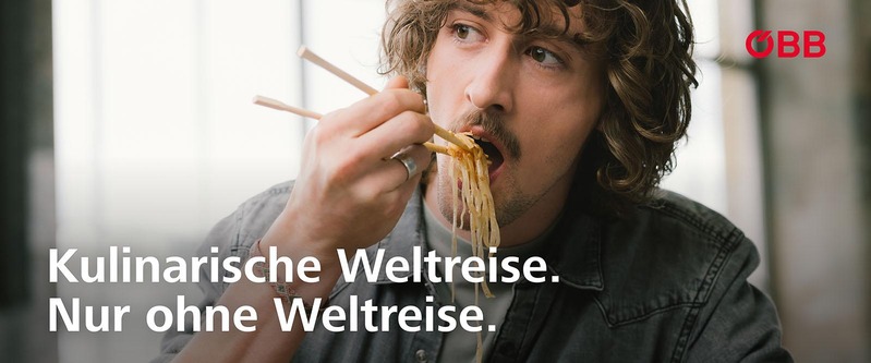 Kulinarische Weltreise. Nur ohne Weltreise: Mann isst asiatische Nudeln mit Stäbchen. 