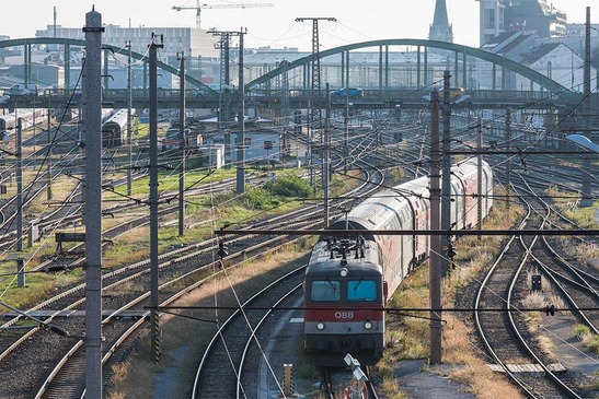 Schienenstränge mit Zug beim Verlassen einer Stadt