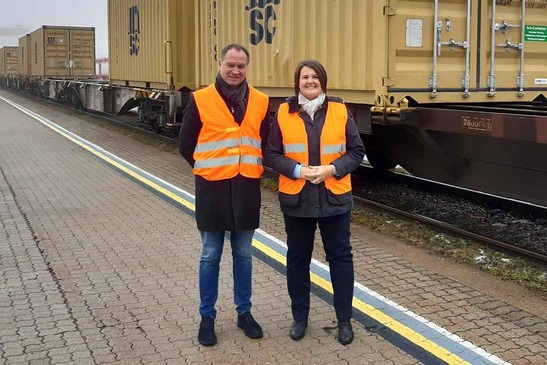 Two people in front of a cargo train