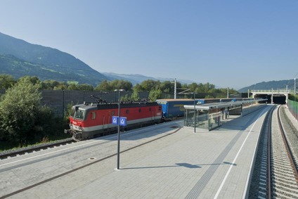 View of a train passing a train station on the Brenner axis