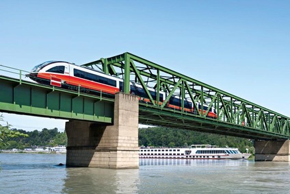 Sujet für Regionalbahnkampagne Donauuferbahn, Eisenbahnbrücke mit Zug und Schiff am Wasser