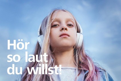 A girl with headphones. Caption: Listen as loud as you want!