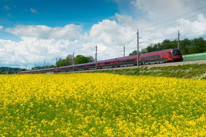 Rapsfeld mit Zug im Hintergrund