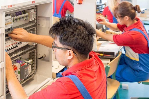 Several apprentices work on the control cabinet