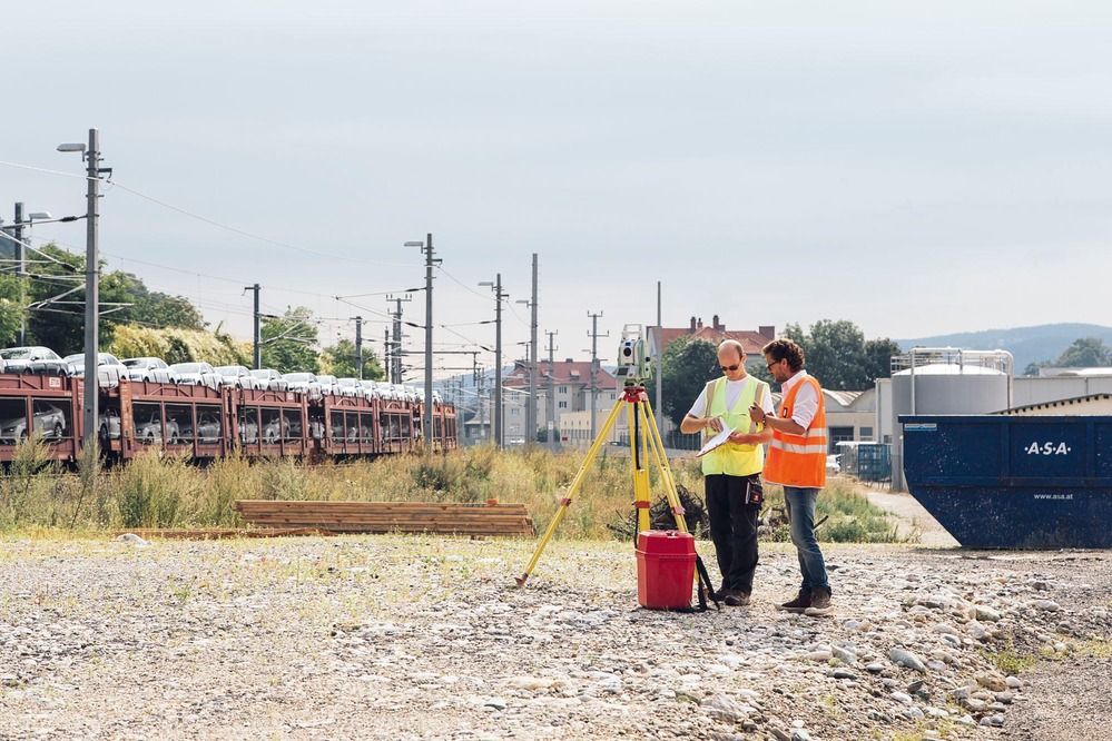 Two specialists measure a potential construction area.