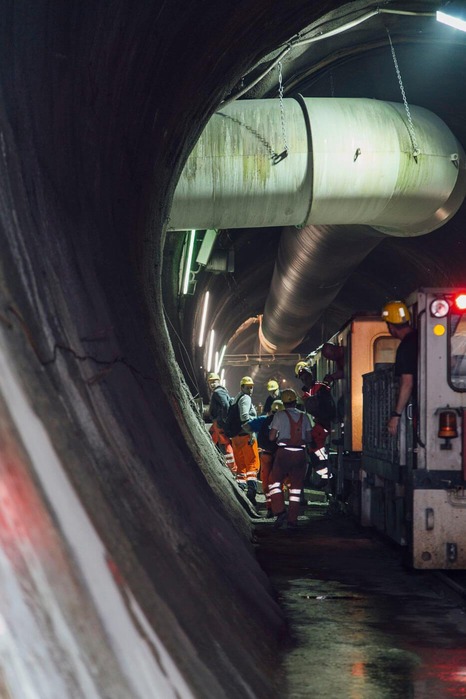 Several miners are transported out of the tunnel by train.