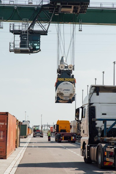A gantry crane loads a container onto a truck.