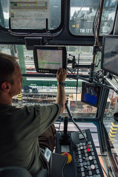 A crane operator adjusts the technical details of a gantry crane.