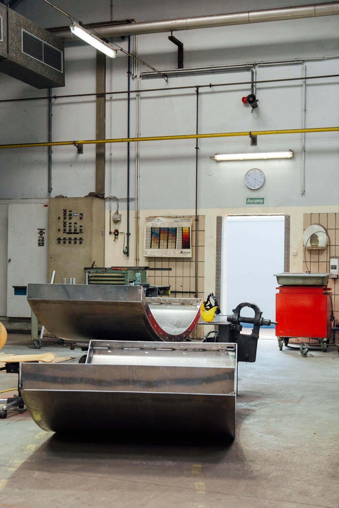 In einer Lagerhalle lagern die bereits geformten Metallteile.