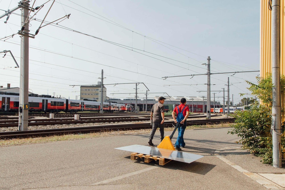 Zwei Konstrukteure transportieren benötigtes Material für die "InfoRail" - Röhre.