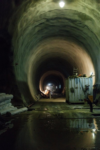 Mehrere Bergbauarbeiter arbeiten in einer Tunnelröhre.