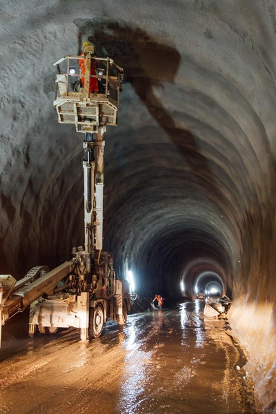 Ein Bergbauarbeiter kontrolliert eine Tunnelwand.