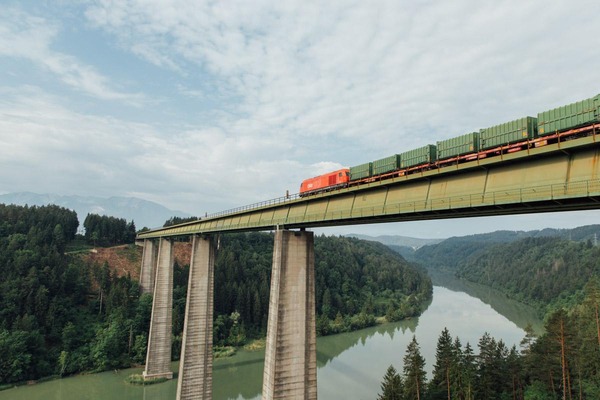 Ein Güterzug überquert eine Eisenbahnbrücke.