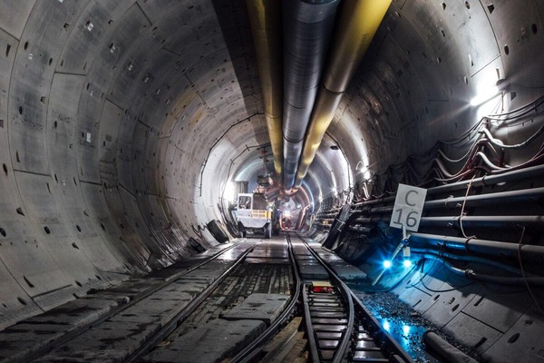Mehrere Bergbauarbeiter arbeiten an der Fertigstellung einer Tunnelröhre.