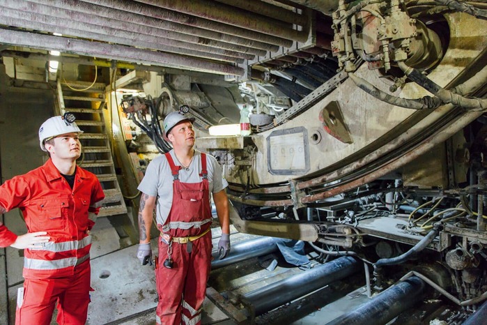 Two mechanics check the functionality of a tunnel drilling machine.