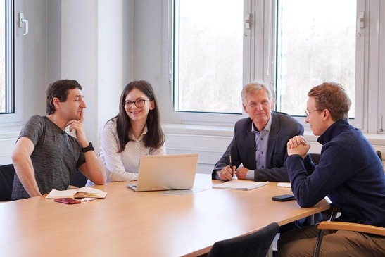 Meeting an einem großen Tisch zu viert. 
