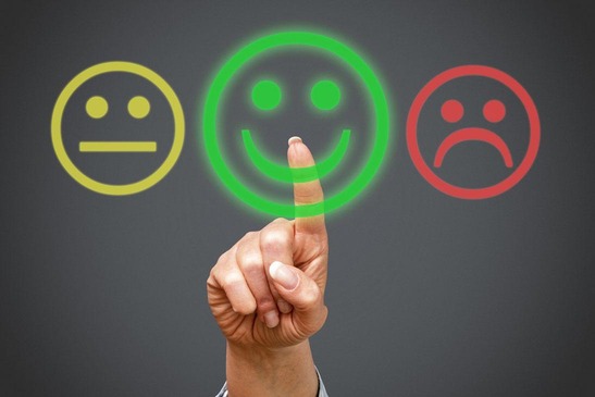 Person bewertet Service und wählt Smiley Icon aus.
