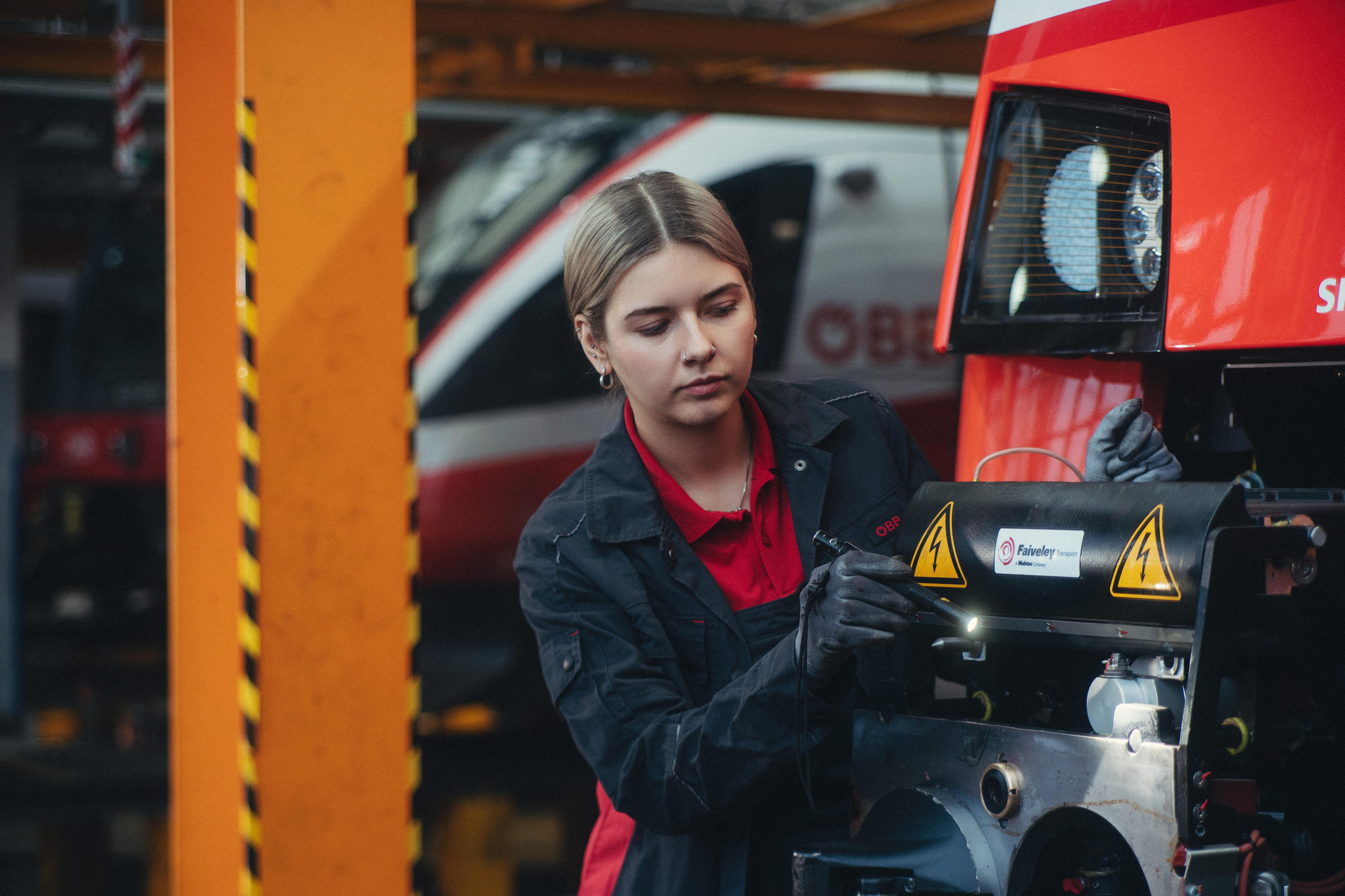 ÖBB Mitarbeiterin in Uniform an einem Zug arbeitend<br/>