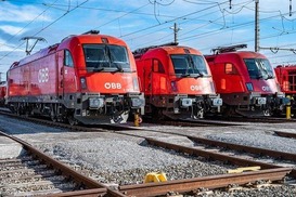 Drei Triebwagen in rot zu sehen bei Sonnenschein.