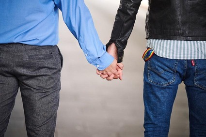 Ein Ausschnitt von hinten von zwei Männer händchenhaltend 