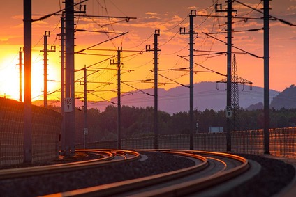 Gleisbogen mit Bahnstromanlagen im Abendrot