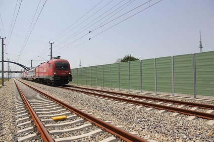 Zug auf einer Strecke mit Schallschutzwand