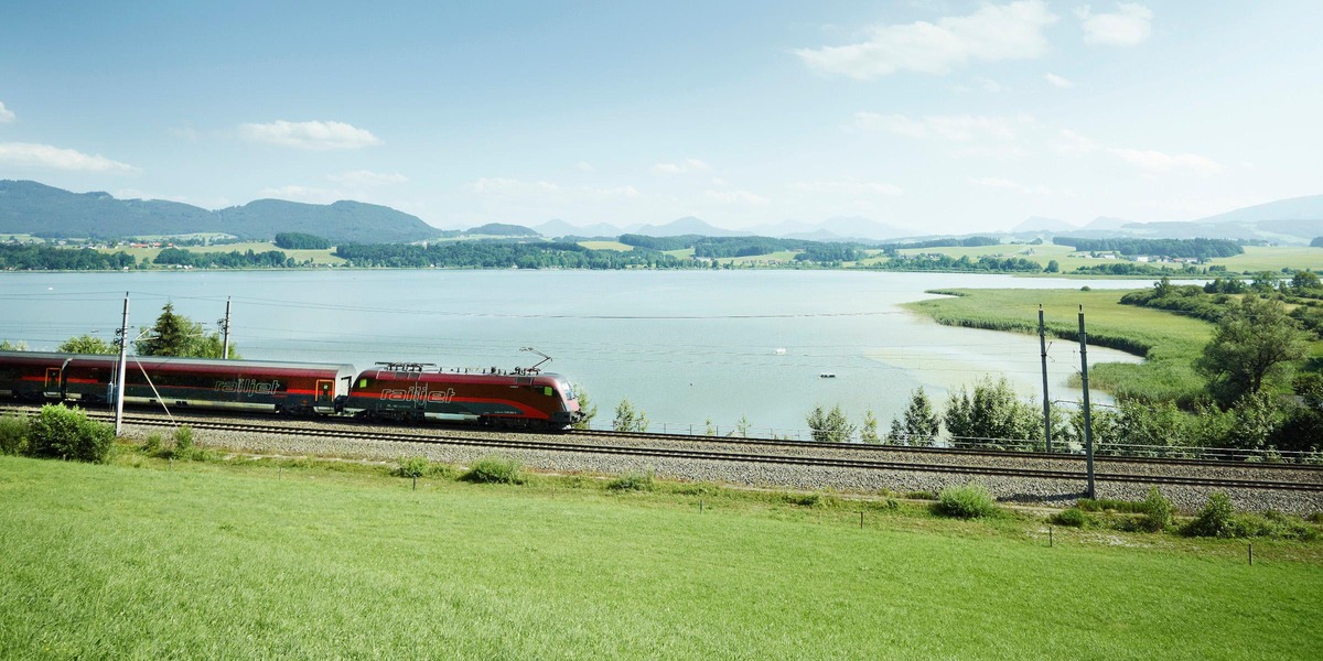 Zug in Landschaft, See dahinter