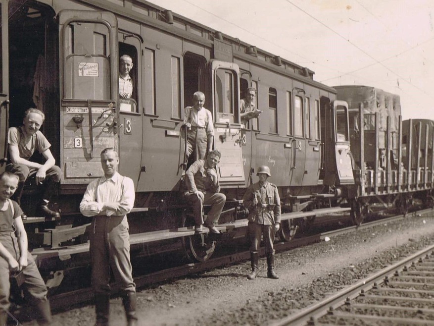 Männer stehen vor und in dem Zug von Polen nach Frankreich