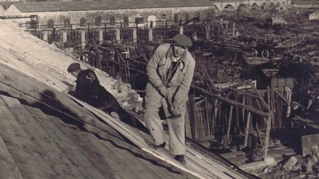 Sowjetischer Zwangsarbeiter bei Dachreparaturarbeiten im Reichsbahnausbesserungswerk Floridsdorf, im Hintergrund die Floridsdorfer Hochbahn