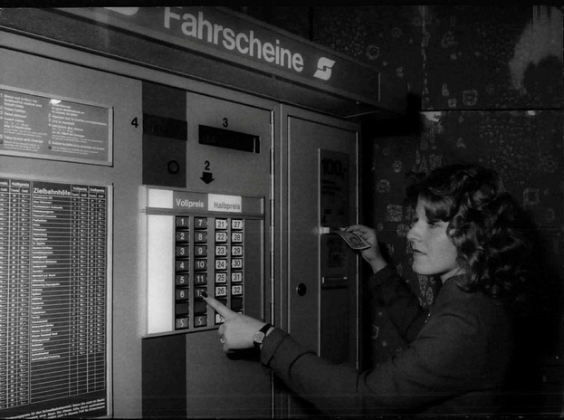 Frau bedient Fahrscheinautomat