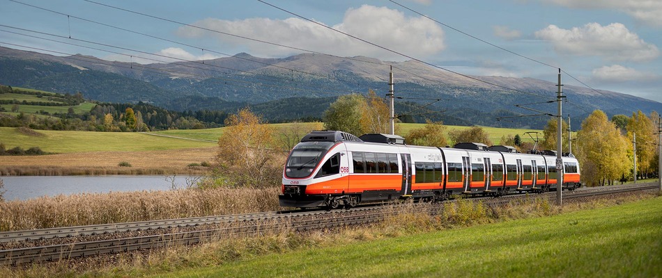 ÖBB Cityjet durchquert Landschaft mit See im Hintergrund