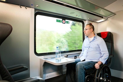 Mann mit Rollstuhl im Railjet