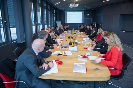 TeilnehmerInnen sitzen am grossen Tisch und diskutieren