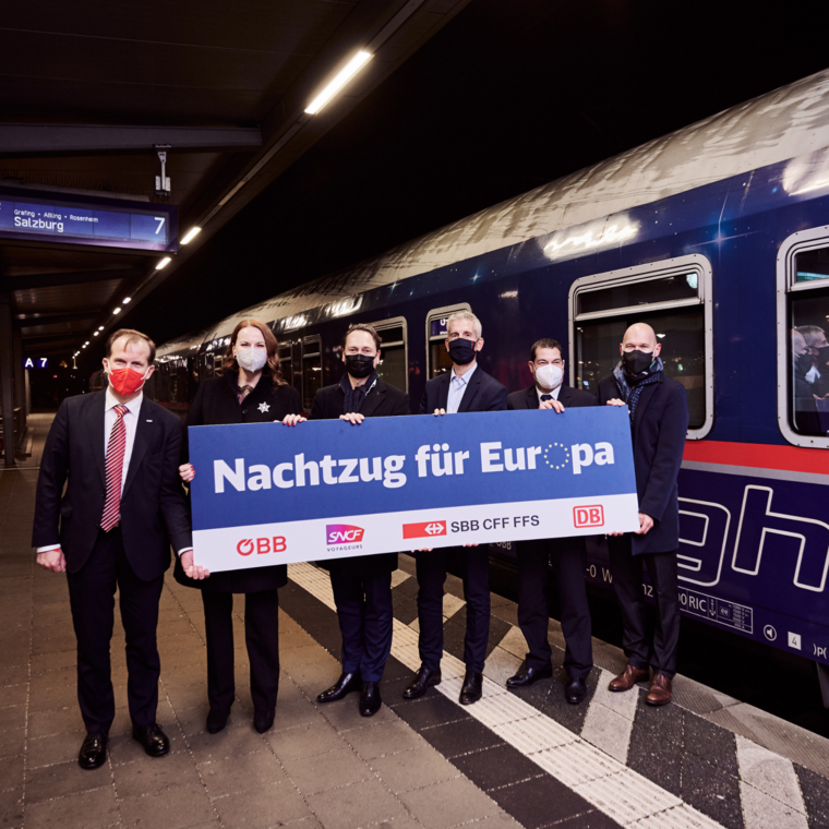 Mitfahrende vor dem Zug