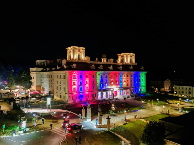 Zu den Sehenswürdigkeiten in Eisenstadt gehört das Schloss Esterhazy. Auf dem Bild sieht man es nachts mit bunter Außenbeleuchtung.