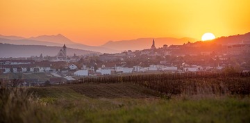 Eisenstadt: Blick auf die Stadt im Abendlicht, dahinter der Himmel mit Sonnenuntergang. 