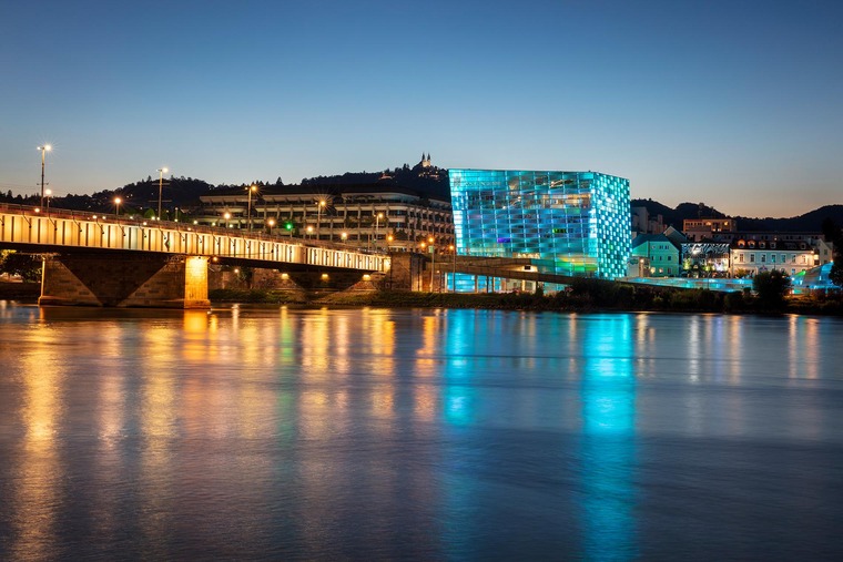 Blick vom anderen Ufer der Donau auf das beleuchtete Ars Electronica Center bei Nacht