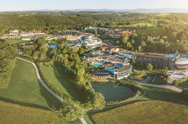 Wellnessen in Österreich: Ein Bllick auf das wunderschöne Thermenresort Loipersdorf von oben. Es ist Sommer, die Natur grün und der Himmel blau. 