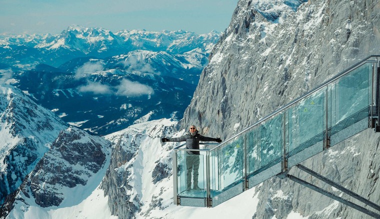 Schladming: Blick auf Dachstein Skywalk im Winter, darauf ein Mann mit ausgebreiteten Armen. 
