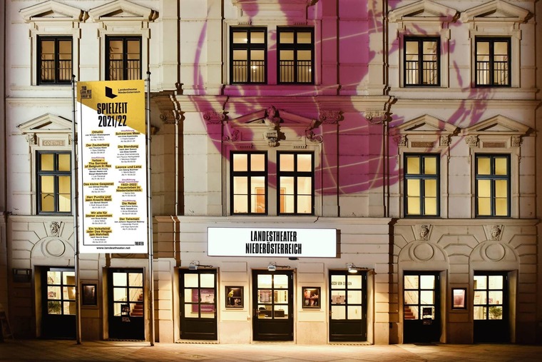 Zu den Sehenswürdigkeiten St. Pölten gehört das Landestheater Niederösterreich. Auf dem Bild sieht man seine beleuchtete Fassade im Abendlicht. 