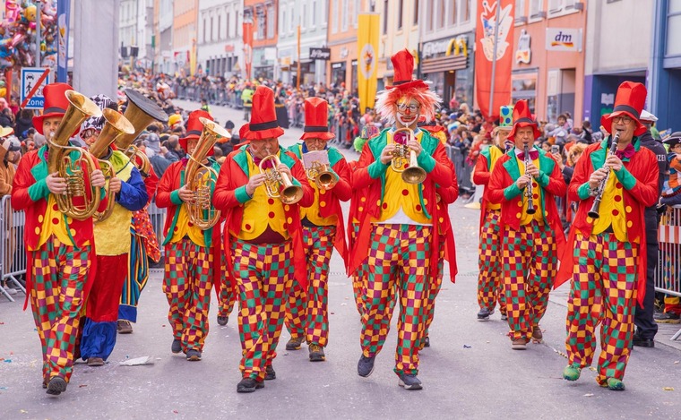 Villacher Fasching: Eine Gruppe verkleideter Clowns geht durch eine Gasse beim Villacher Faschingsumzug. 