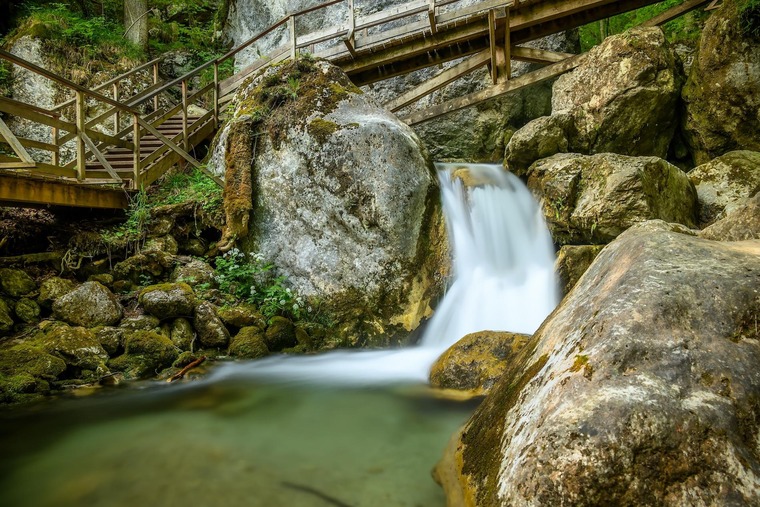 Ausflugsziele rund um Wien: Die Myrafälle in Niederösterreich sind wunderschön. Im Bild sieht man einen Teil der Fälle samt Holzbrücke, daneben bemooste Steine. 