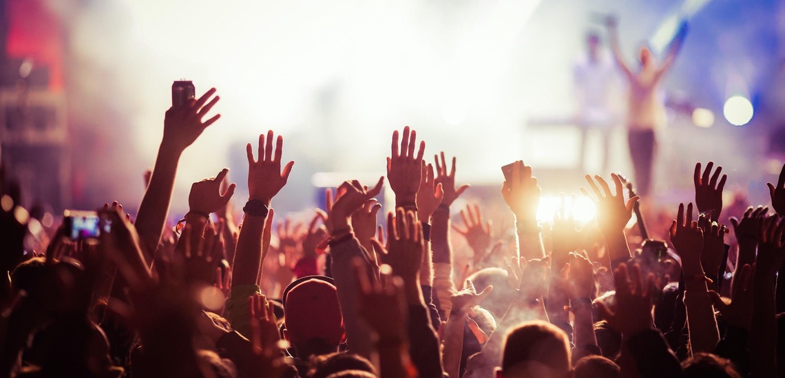 Die besten Festivals in Österreich 2026: Im Bild sieht man Hände und Arme, die von einem Konzertpublikum in die Höhe gestreckt werden. 