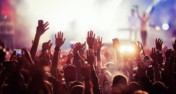 Die besten Festivals in Österreich 2026: Im Bild sieht man Hände und Arme, die von einem Konzertpublikum in die Höhe gestreckt werden. 