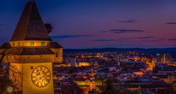 Graz Sehenswürdigkeiten: Der Uhrturm bei Nacht, mit Blick auf die Stadt