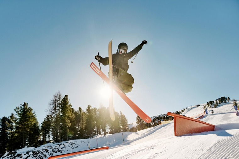 Mit dem Zug zur Piste: Im Skigebiet Kreischberg wartet auch ein Snowpark. Auf dem Bild sieht man einen Skifahrer im Sprung nach einer Schanze. 