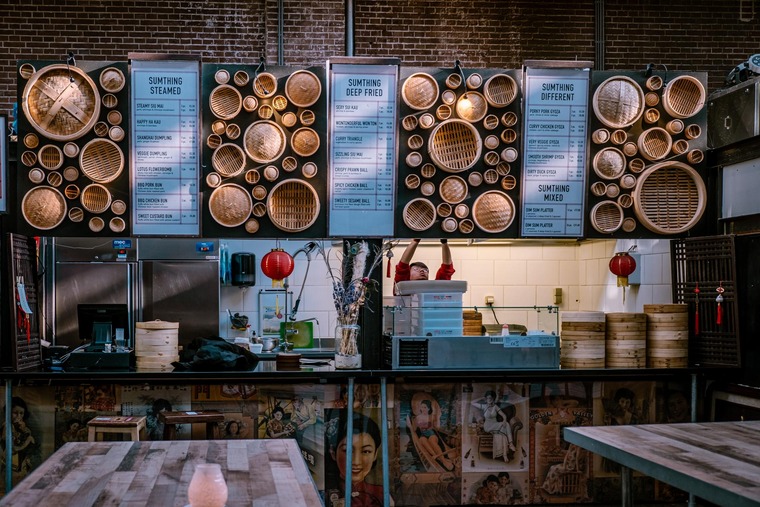 Zu den Sehenswürdigkeiten in Amsterdam gehören die Food Hallen. Auf dem Bild befindet sich ein Food-Stand.