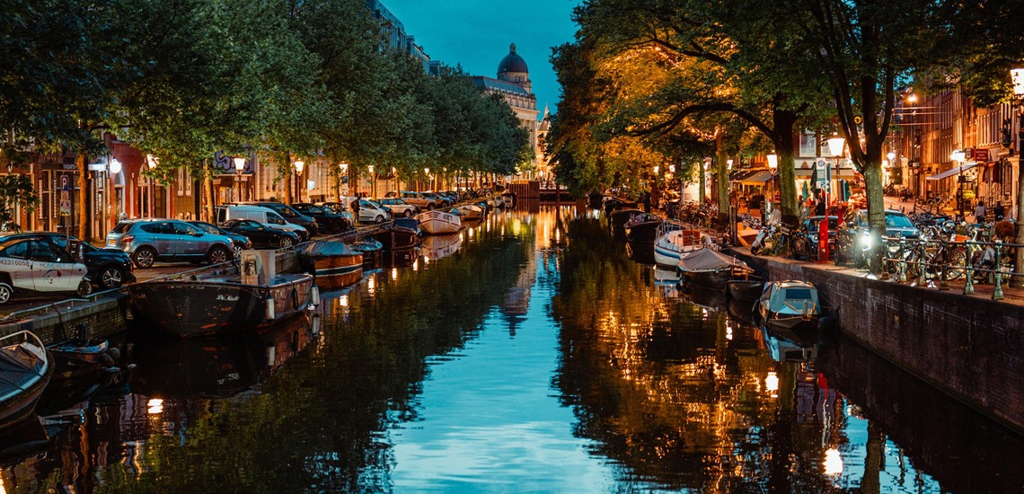 Zu den Amsterdam Sehenswürdigkeiten gehören natürlich die Grachten. Blick auf eine Gracht im Abendlicht.