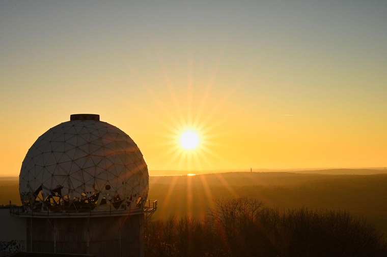 Berlin Sehenswürdigkeiten: Blick auf den Sonnenuntergang vom Teufelsberg aus. Links im Bild die verfallende Abhörstation der Amerikaner. 
