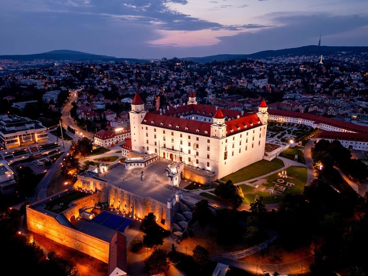 Zu den Bratislava Sehenswürdigkeiten gehört die Burg. Das Bild ist eine Luftaufnahme bei Nacht. 